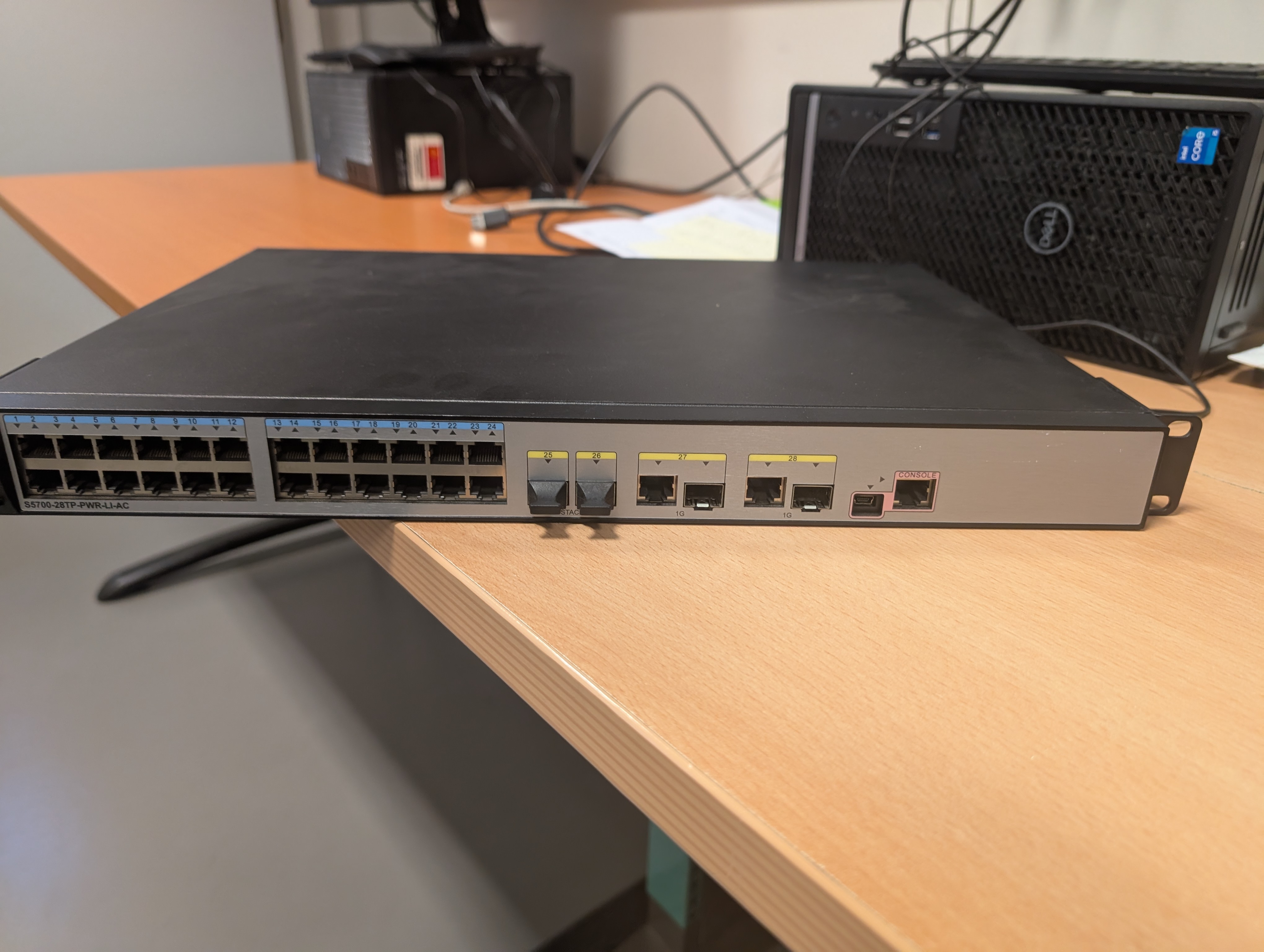Face avant du S5700-28TP-PWR-LI-AC : le port CONSOLE (RJ45 rose) à droite est le point d'entrée de la réinitialisation.